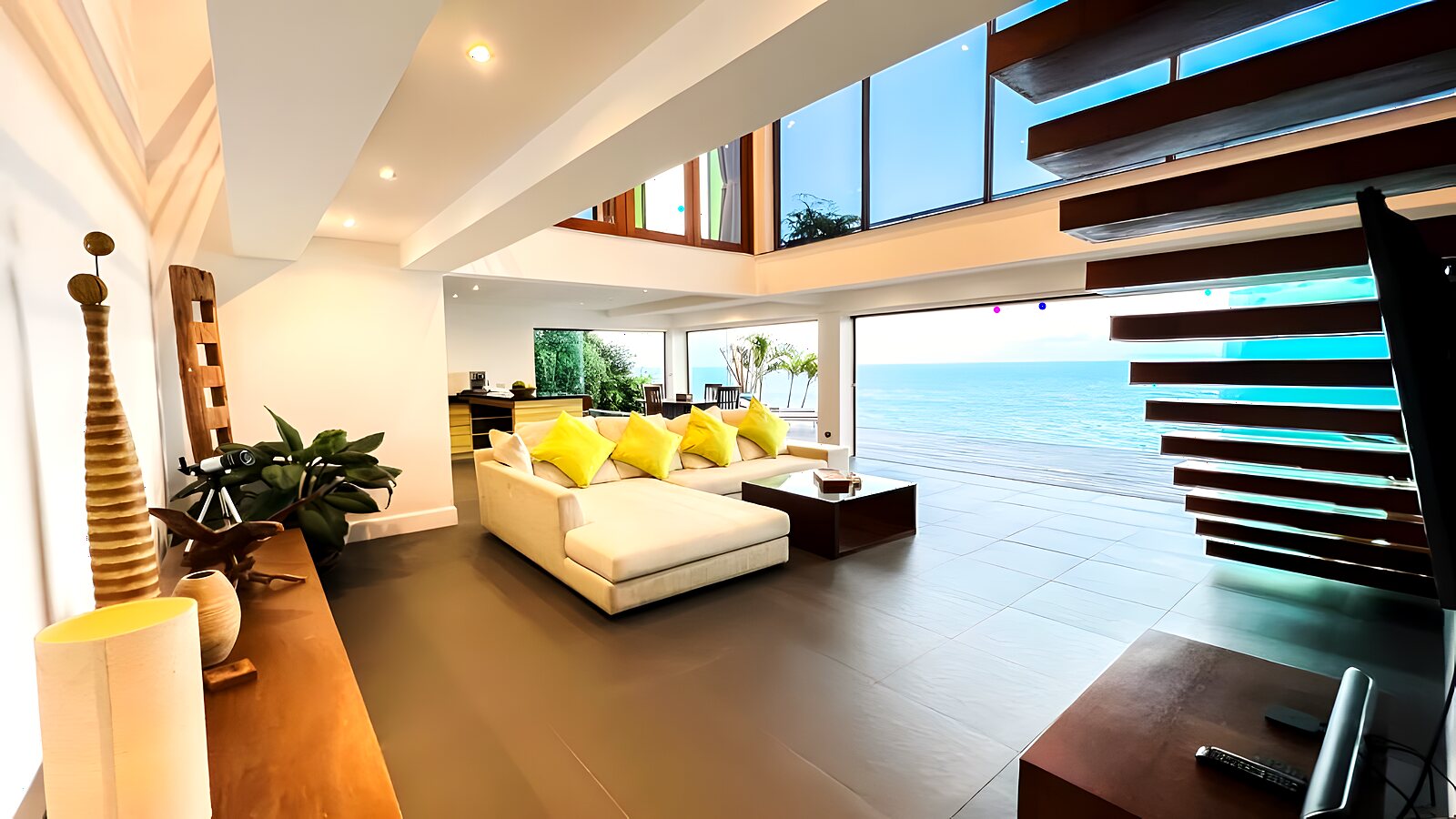 Open-plan living room with white sofas and floor-to-ceiling glass