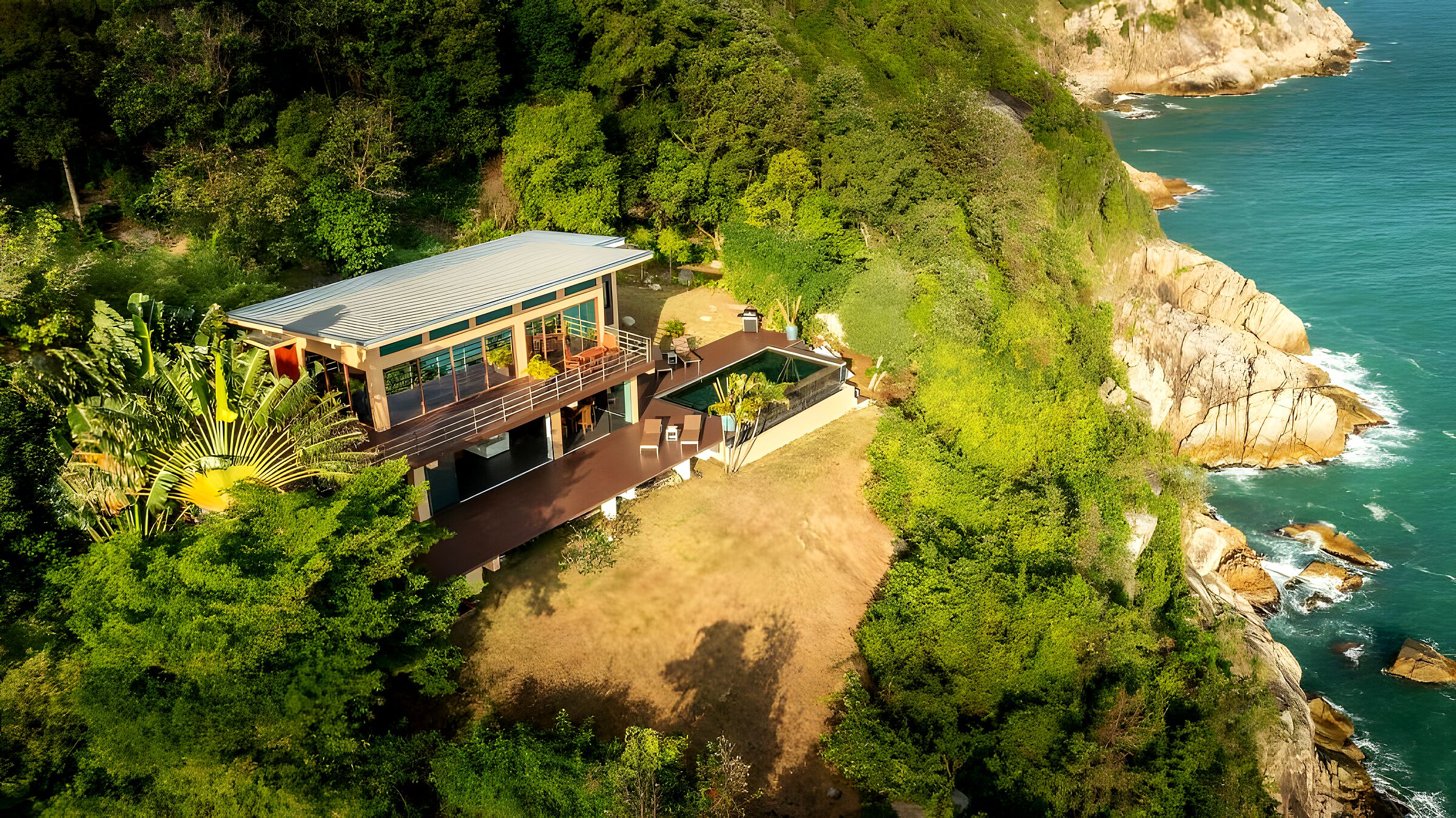 Aerial view of The Hideaway, a lone contemporary villa on a jungle cliff above the turquoise Gulf of Thailand